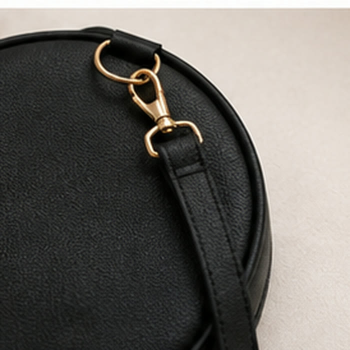 Gold clasp against onyx black vegan leather