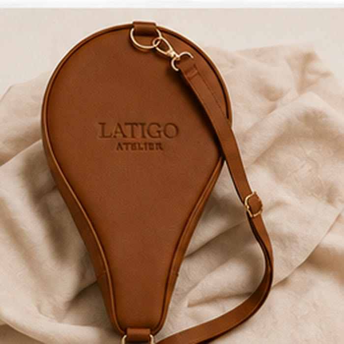 Saddle tan padel cover resting on linen